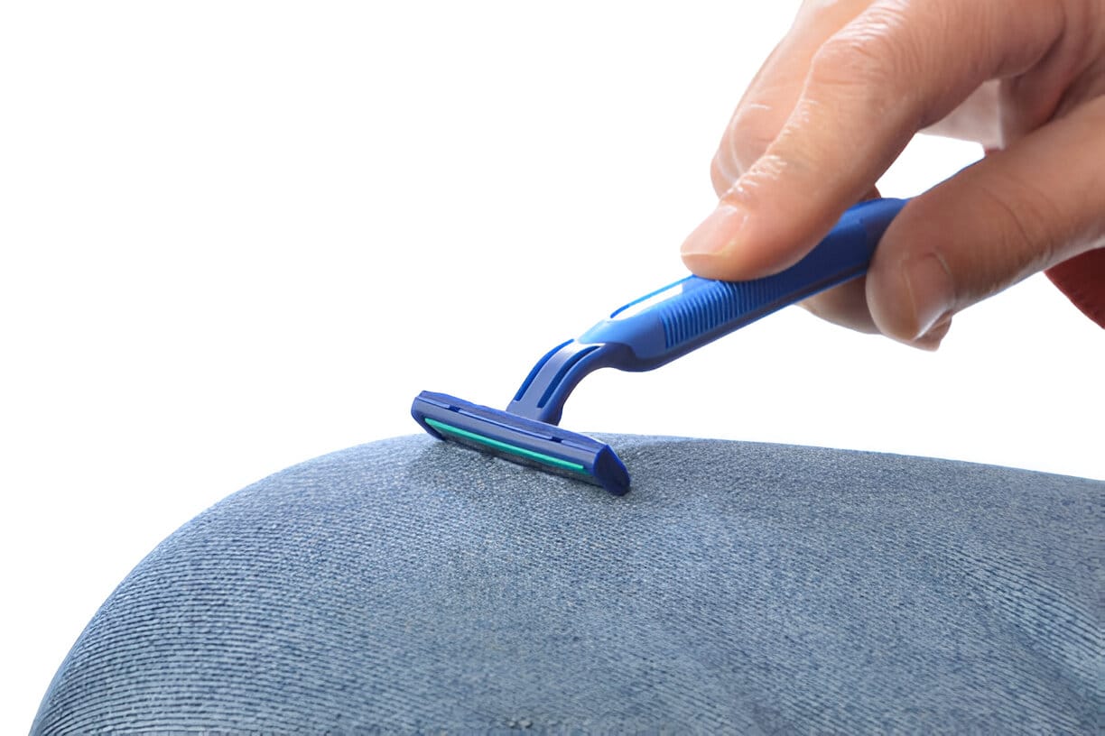 Personne affûtant une lame de rasoir sur un jean