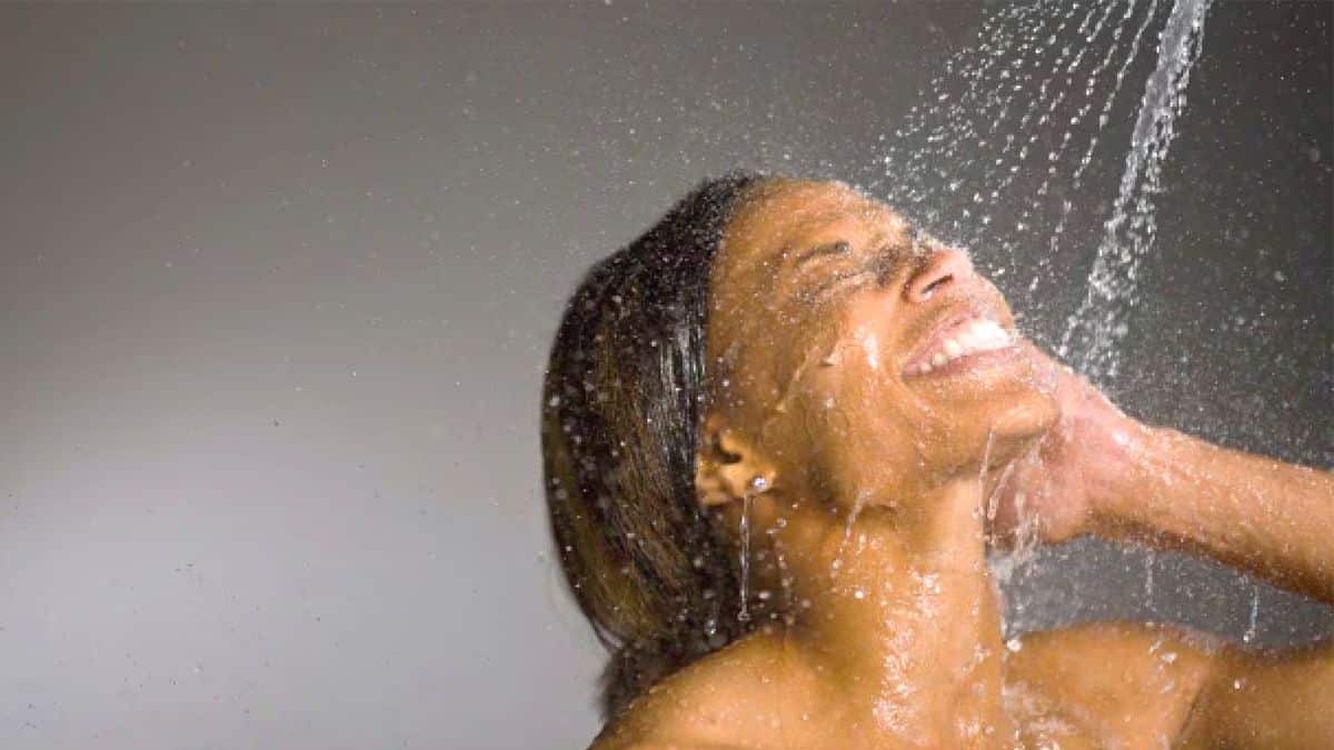 Personne se lavant le visage sous la douche