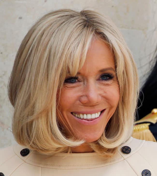 Brigitte Macron souriante avec sa frange signature