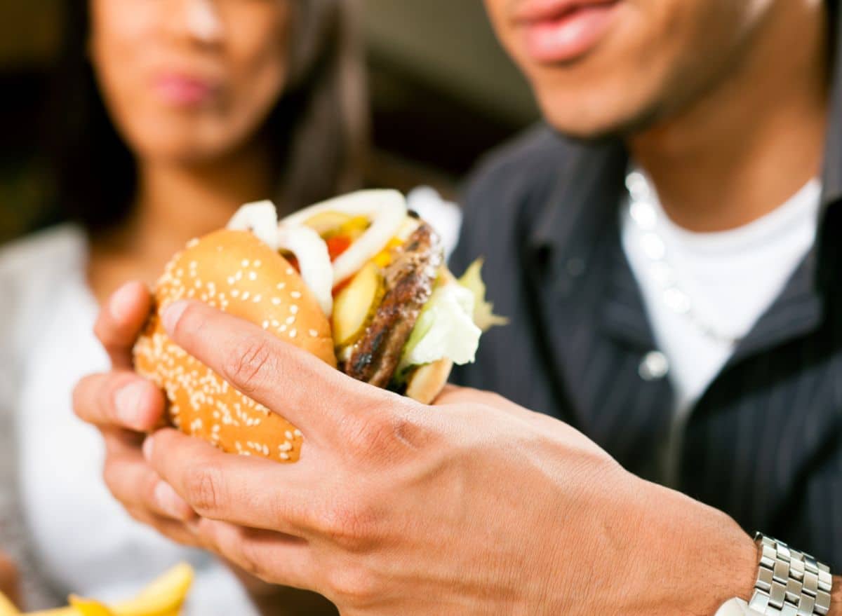 Personne mangeant un burger dans un fast-food