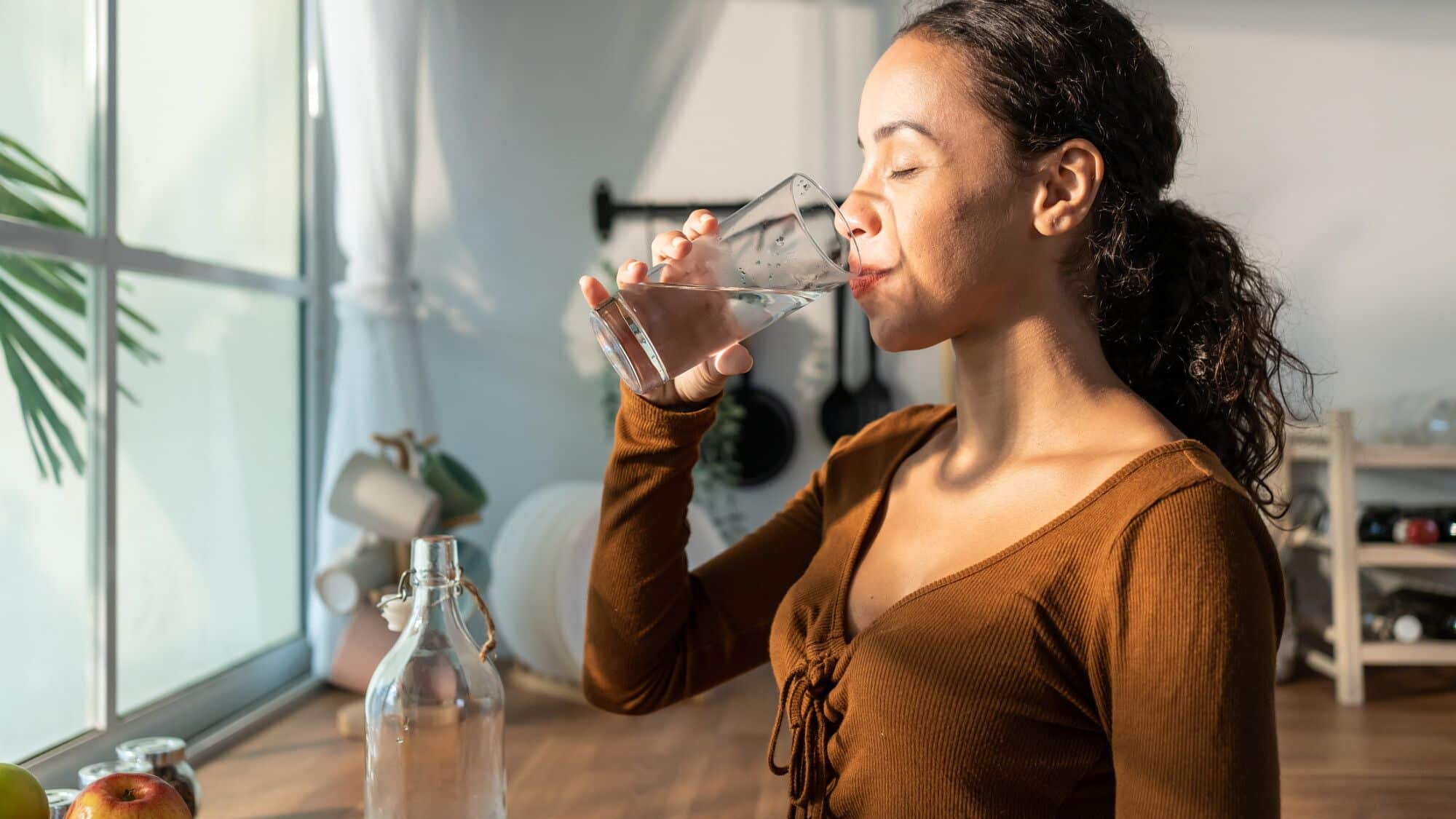 Jeune femme buvant de l'eau
