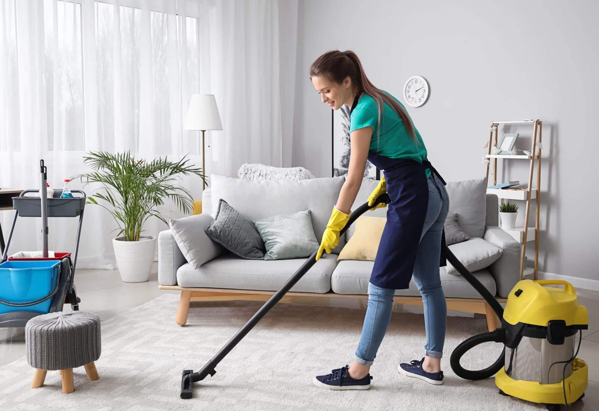 Femme souriante en train de nettoyer sa maison
