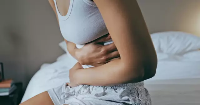 Femme utilisant une bouillotte pour soulager ses douleurs menstruelles
