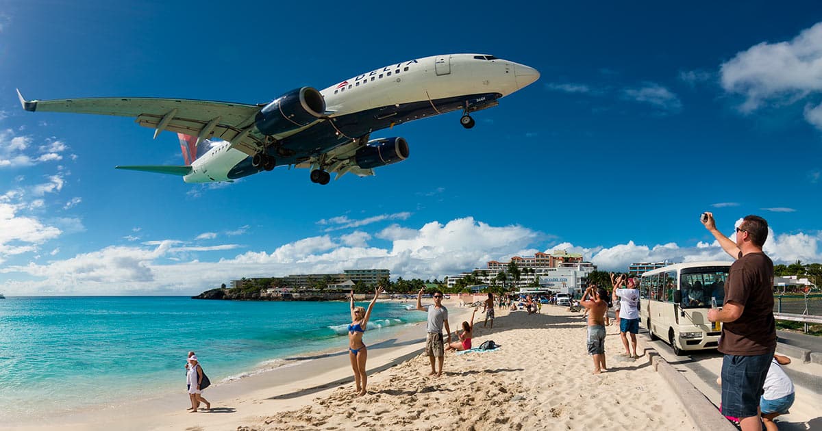 Gros porteur volant au ras des touristes sur la plage