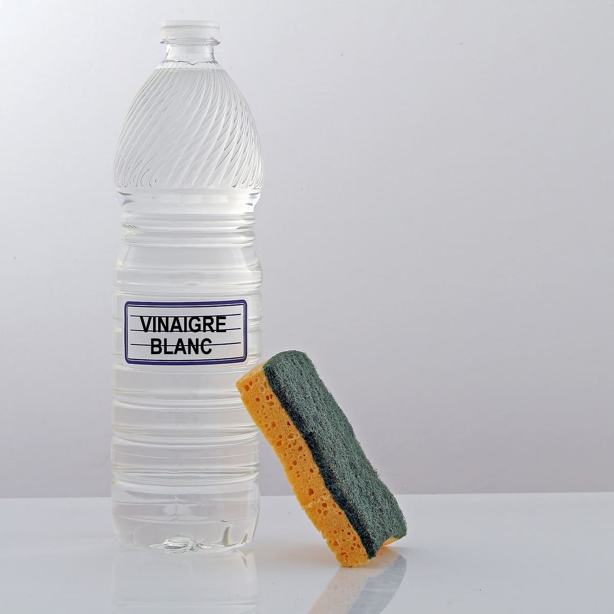 Bouteille de vinaigre blanc et éponge