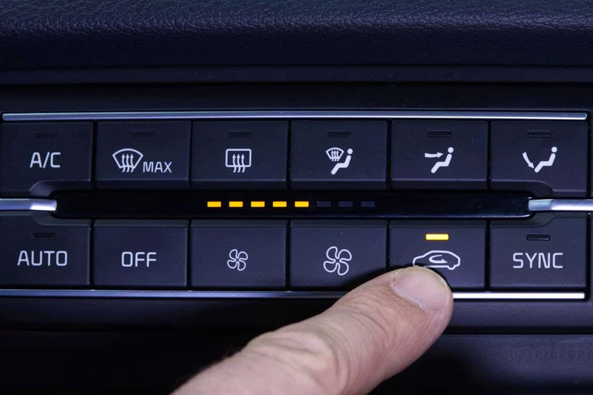 Main appuyant sur le bouton de recirculation