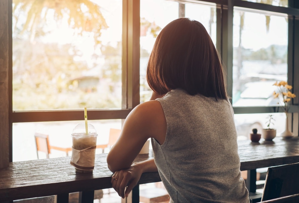 Femme souriante appréciant un moment de solitude dans un café