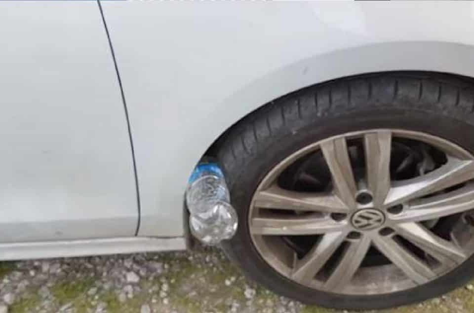 Bouteille en plastique coincée contre un pneu de voiture