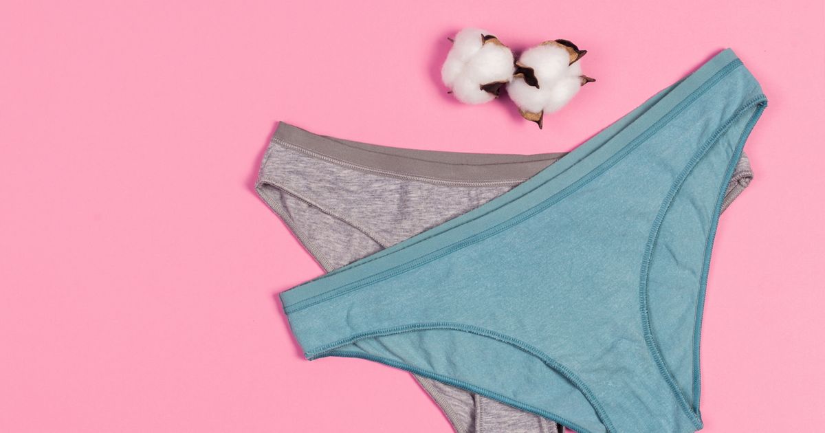 Femme souriante tenant une culotte avec gousset visible