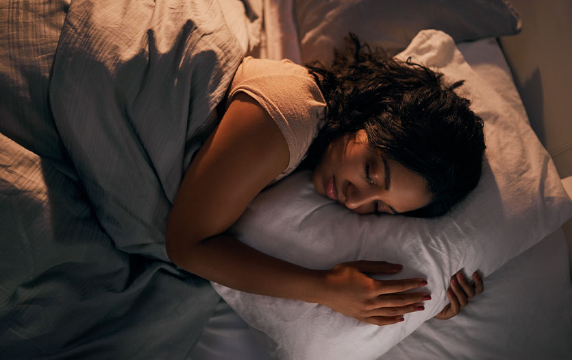Femme dormant sur le côté avec oreiller ergonomique