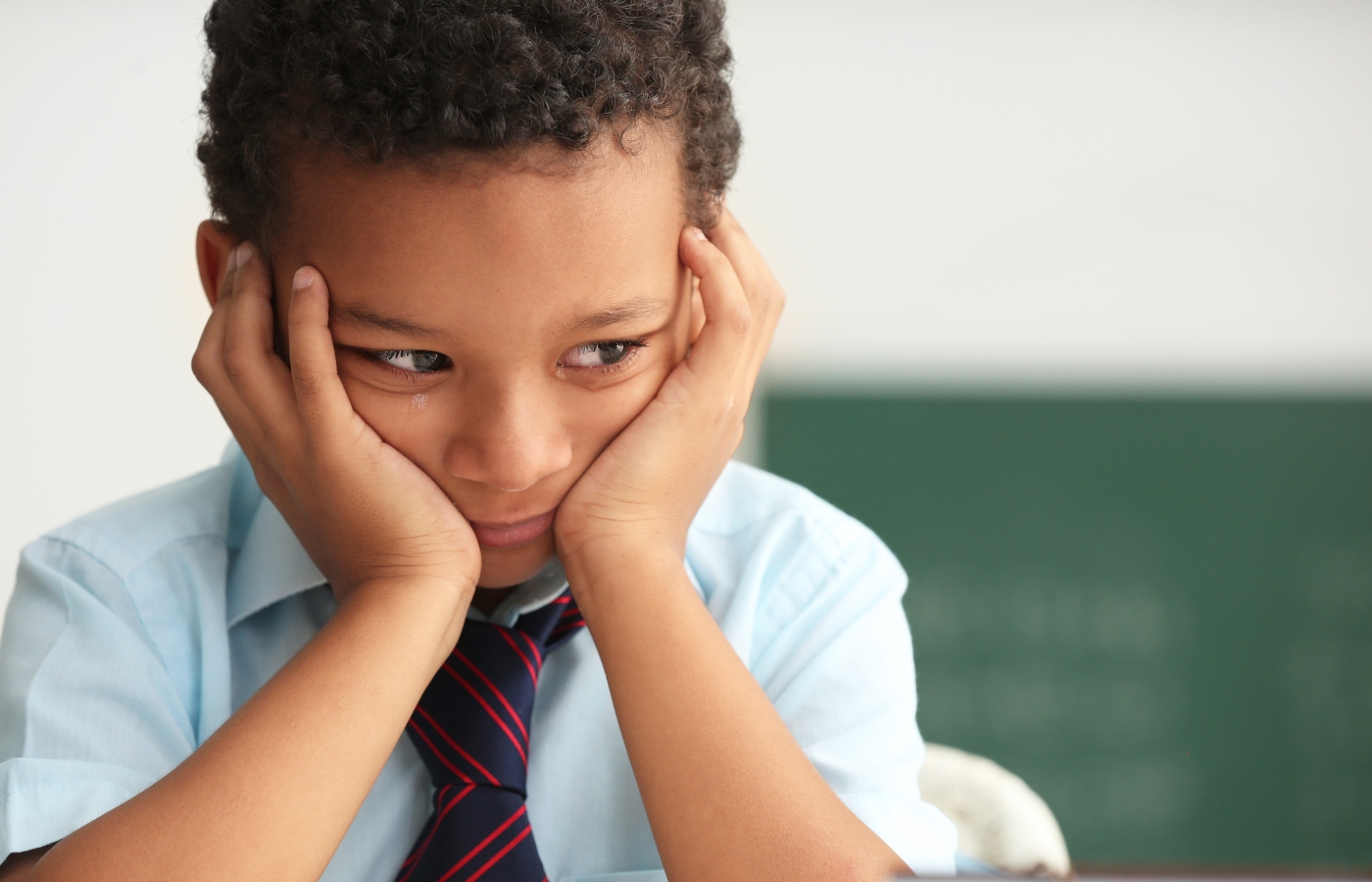 Enfant découragé devant son bureau