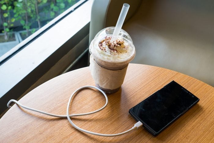 Téléphone en charge dans un café avec une boisson