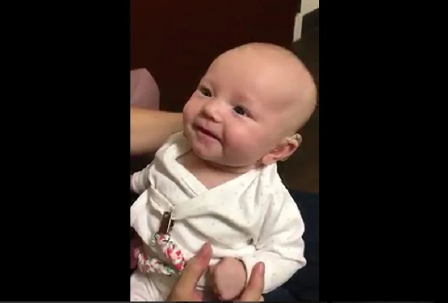 Sourire radieux du bébé entendant sa maman pour la première fois