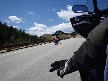 Motard faisant un signe de la main en conduisant