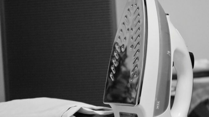 Fer à repasser avec des traces sur la semelle montrant des dépôts et saletés