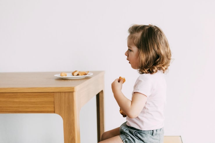 Petite fille assise à table