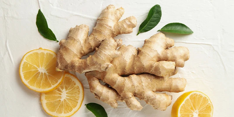 Racine de gingembre et quartiers de citron préparés, montrant les composants du remède naturel
