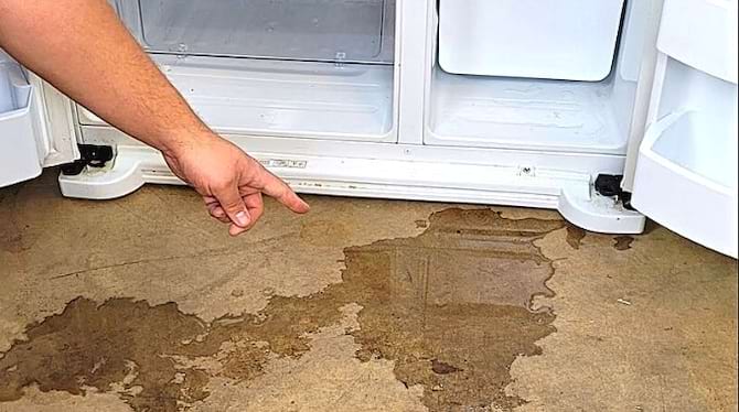 Flaque d'eau au pied d'un réfrigérateur