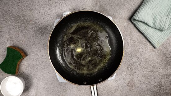 Nettoyage d'une poêle avec une demi-tomate