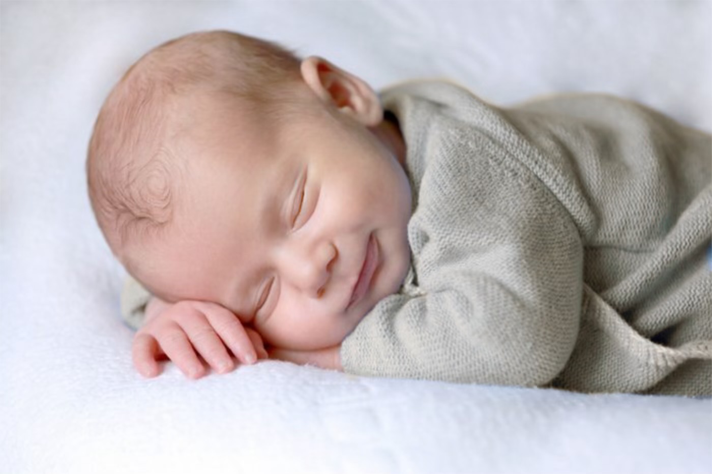Jeune garçon berçant tendrement un bébé dans ses bras