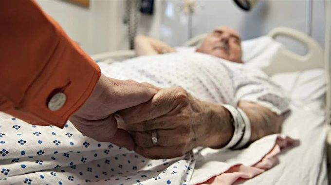 Main d'une personne âgée tenue avec tendresse