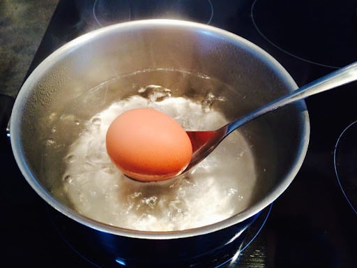 Casserole avec des œufs dans de l'eau froide sur une plaque de cuisson