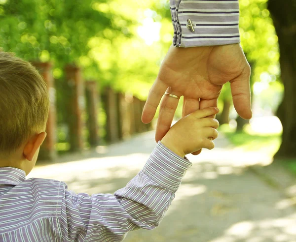 Main d'un adulte tenant celle d'un enfant, symbole de lien familial