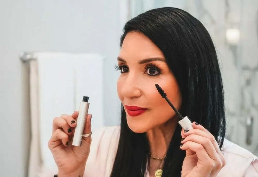 Femme appliquant délicatement du maquillage léger