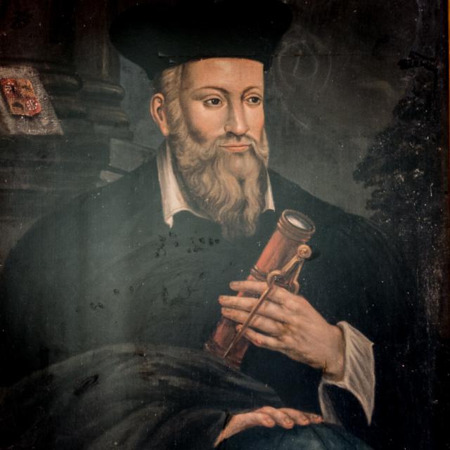 Vieille illustration colorée représentant Nostradamus en train d'écrire