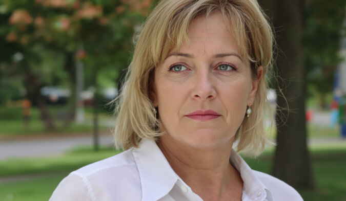 Femme regardant par la fenêtre, pensive, dans un intérieur