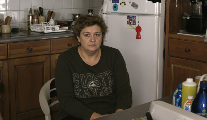 Femme pensive regardant par la fenêtre, expression préoccupée