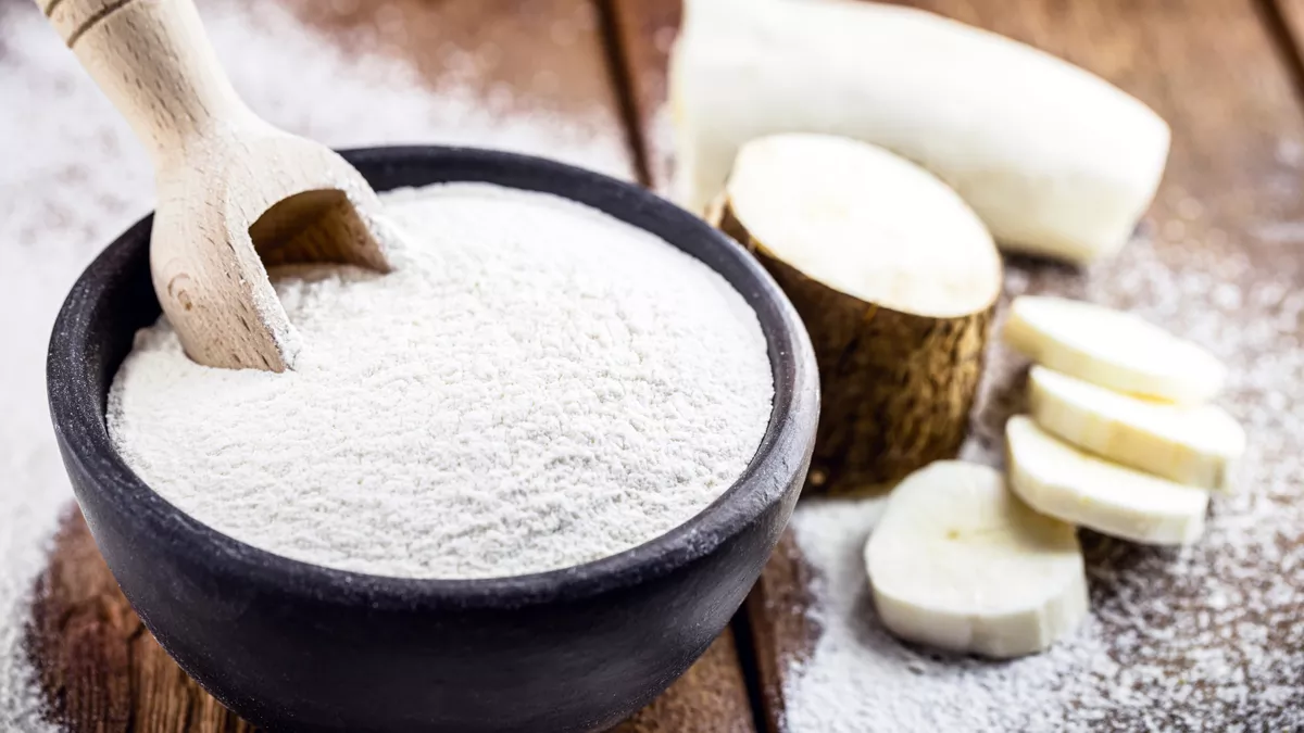 Cuillère en bois de farine de tapioca nature sur un fond en bois