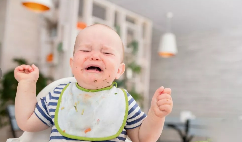 Une femme semblant stressée dans un avion, tenant un bébé