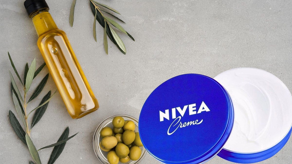 Bol en céramique contenant un mélange crémeux de crème Nivea et d'huile d'olive, avec une spatule en bois